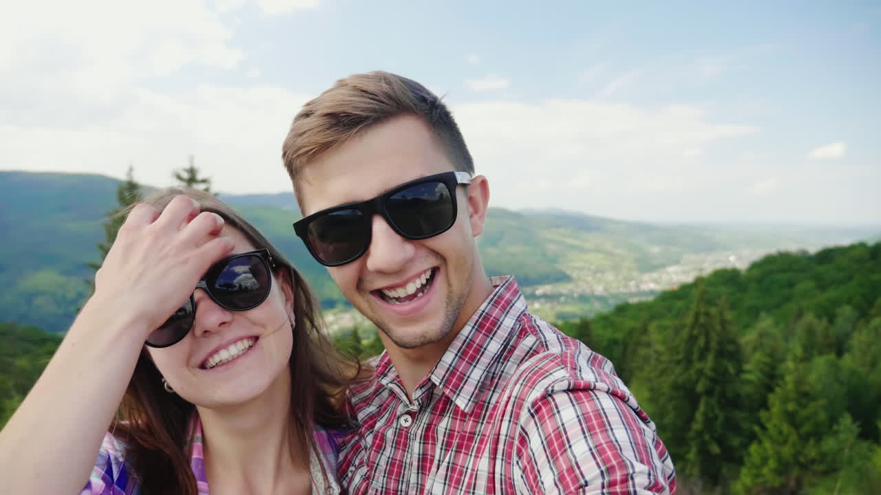 아름다운 산의 멋진 휴가와 휴가를 배경으로 셀카를 찍는 행복한 커플