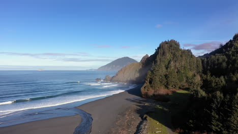 drone rises over empty oregon coast beach in morning light