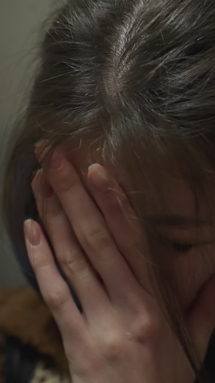 un primer plano de una niña llorona apoyándose en la pared de un túnel subterráneo. ella parece profundamente infeliz, con su mano cubriendo parcialmente su rostro, un momento de intensa vulnerabilidad emocional