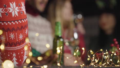 tiro de ángulo bajo de un grupo de amigos celebrando la navidad en un bar