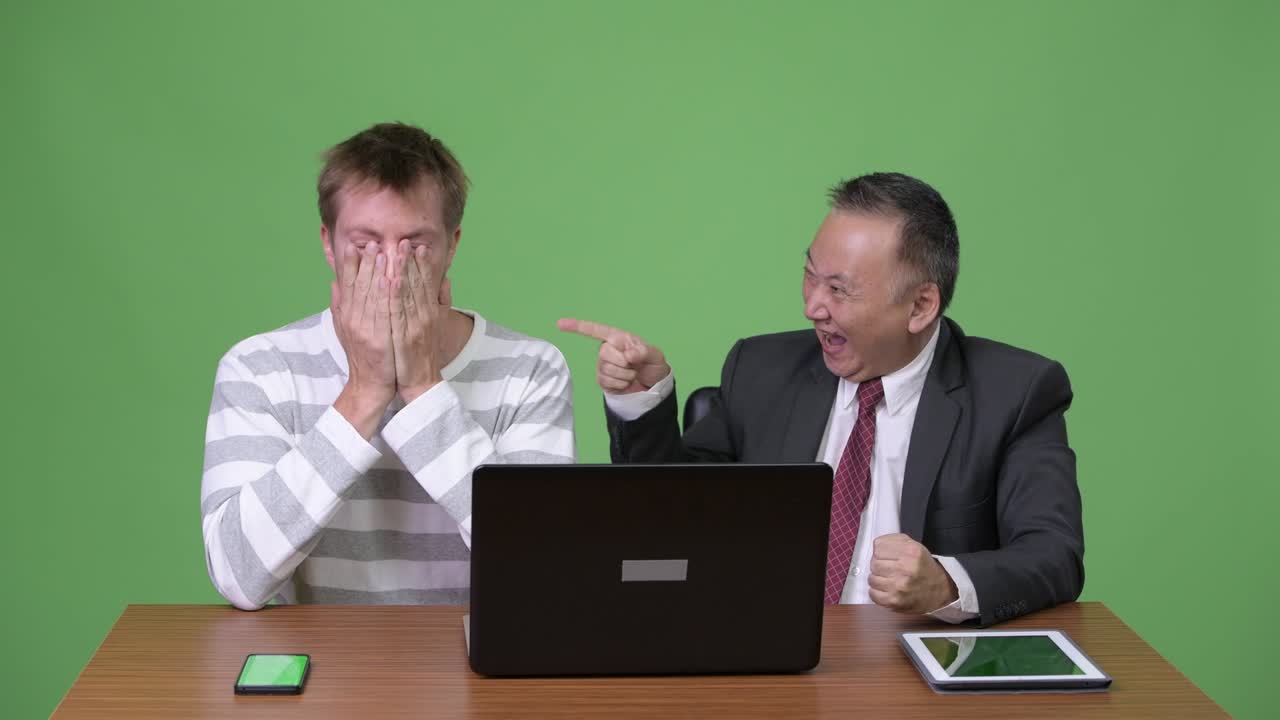 성숙한 일본 사업가와 젊은 스칸디나비아 사업가가 함께 일하고 있습니다.