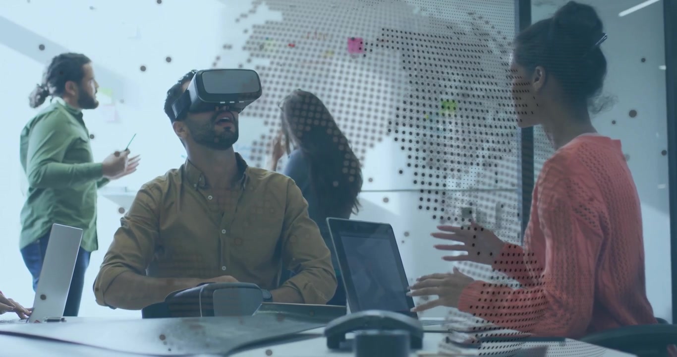 Team exploring tech interface while arranging notes on world-map after fitting VR headset