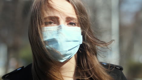 portrait of girl with a face mask and sad eyes walking, looking at camera, close up slow motion