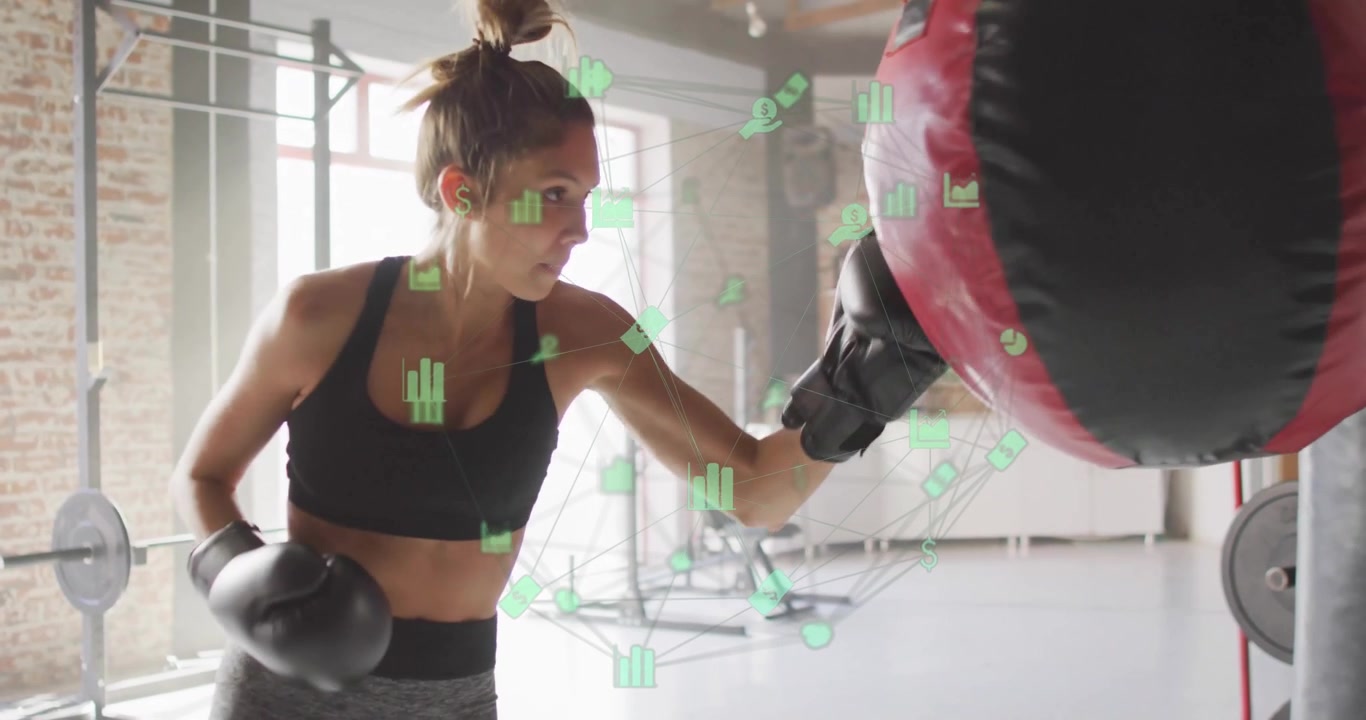Young Woman Training with Punching Bag in Gym with Digital Data Overlay