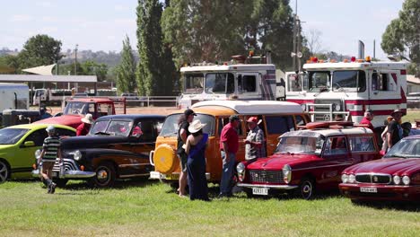 la gente admira los coches clásicos en un evento al aire libre