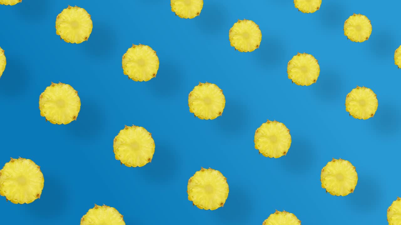 Pola buah berwarna-warni nanas segar di latar belakang biru dengan bayangan. Pola tanpa sambungan dengan irisan nanas. Animasi realistis. Gerakan video 4K.