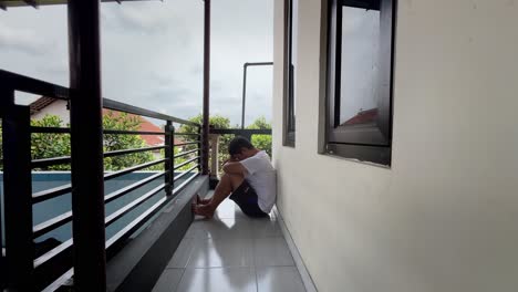 a gloomy person sits leaning against the wall