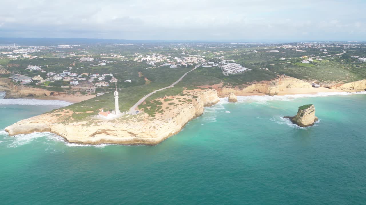 Lighthouse on Algarve coast, ocean cliffs and Ferragudo town in sunny Portugal