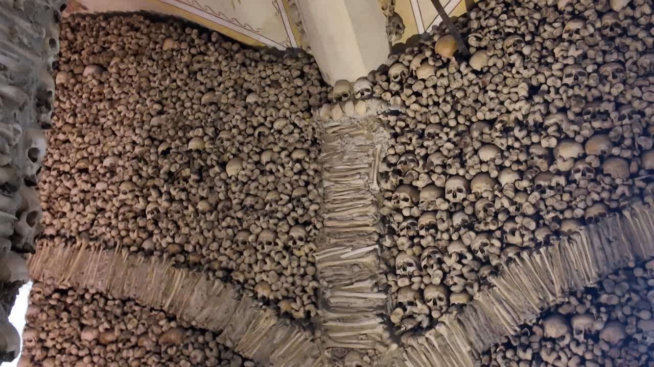 Human skulls and bones decorating the interior of the Chapel of Bones in Evora, Portugal, creating a macabre and historical landmark