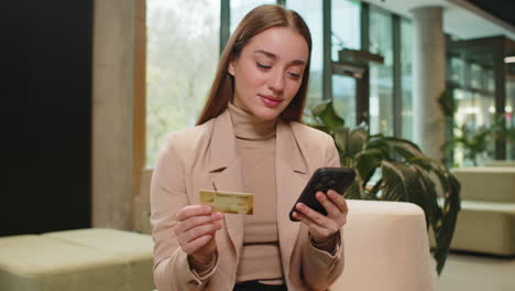 Businesswoman using credit bank card and smartphone transferring money purchases online shopping