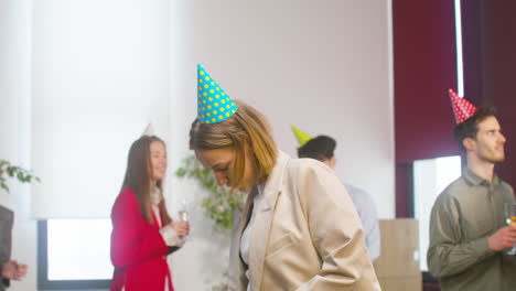 Mujer-Rubia-Feliz-Bailando-Y-Divirtiéndose-En-La-Fiesta-De-La-Oficina