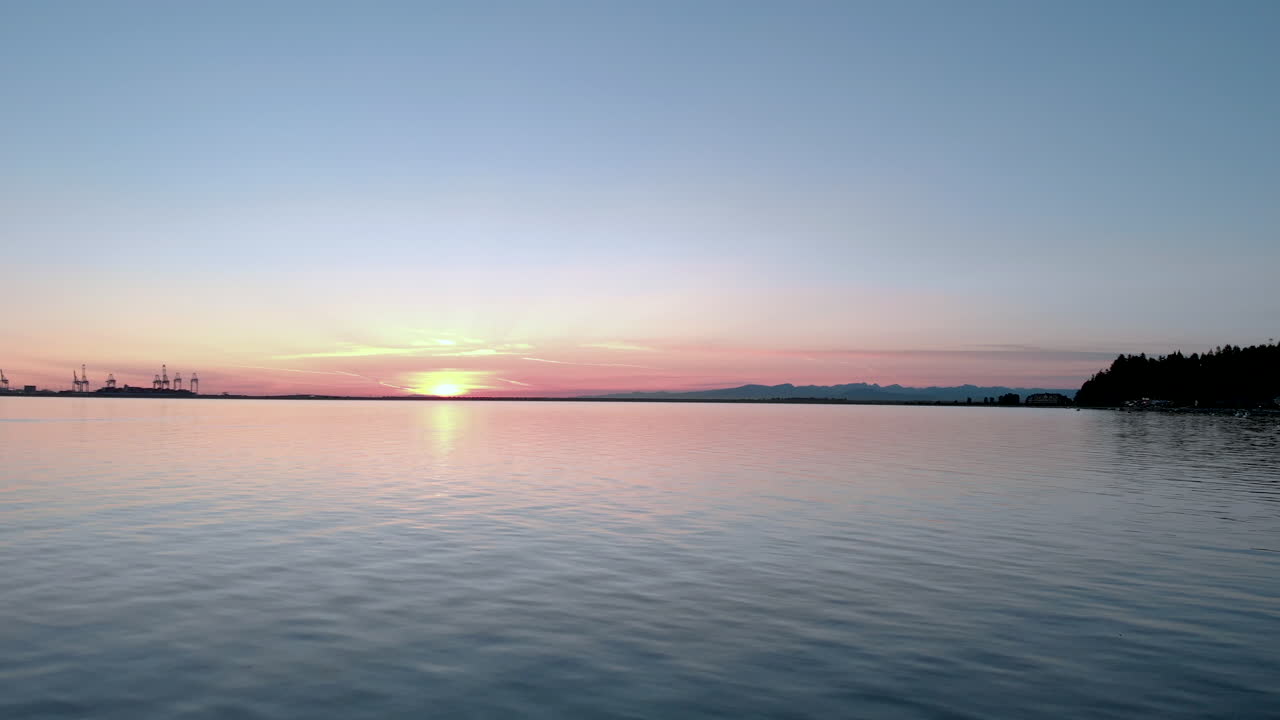vuelo a baja altitud sobre el agua con un hermoso sol naranja poniente