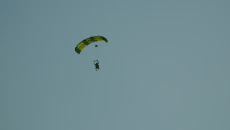 tracking shot of skydiver flying in the air against blue sky in poland - wide shot bottom up