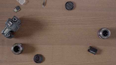 overhead shot of camera equipment, dslr equipment, on a wooden surface