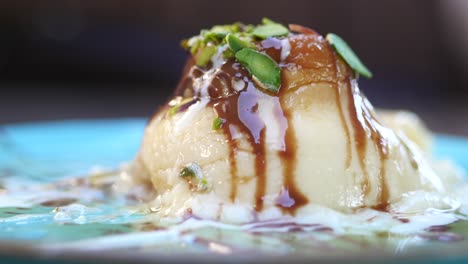 close-up of a delicious dessert with chocolate sauce, pistachios, and cream