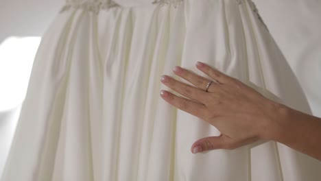 hand of beautiful bride touches wedding dress. pretty and well-groomed woman