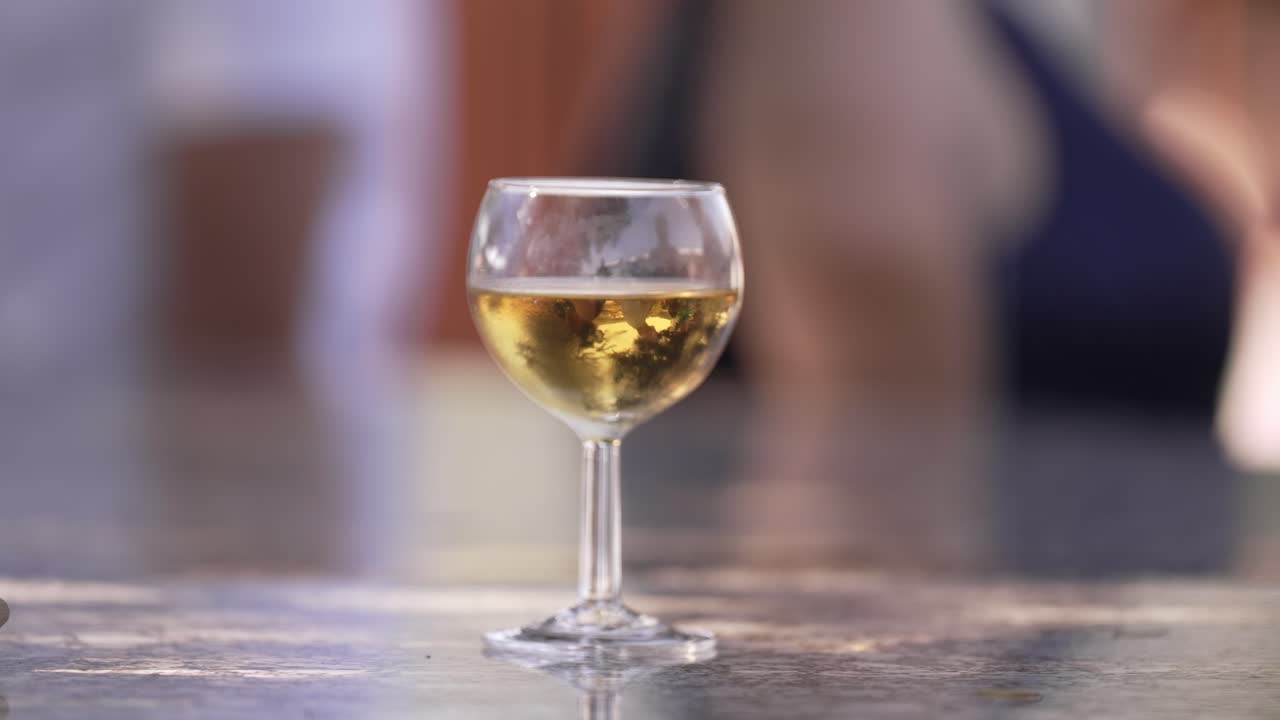 cerrar un vaso de vino blanco en una mesa durante una reunión al aire libre