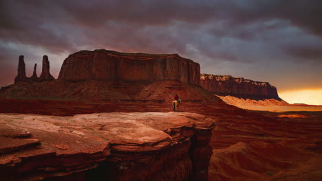 Cinemagraph---Nahtloser-Video-Loop-Zeitraffer-Eines-Navajo-Indianers-Auf-Einem-Pferd,-Der-Bei-Sonnenuntergang-über-Die-Berühmten-Felsformationen-Am-Wahrzeichen-Des-Monument-Valley-In-Utah---Arizona,-Amerika---USA-Blickt