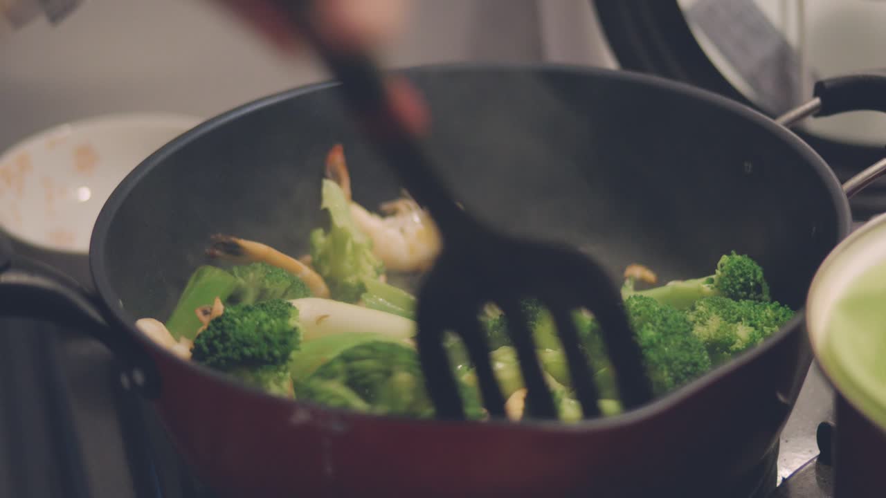 Cooking And Pouring Soy Sauce Into The Stir-Fried Brocolli With Prawns On The Frying Pan