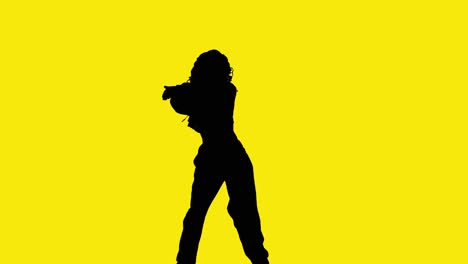 studio silhouette of woman dancing against yellow background