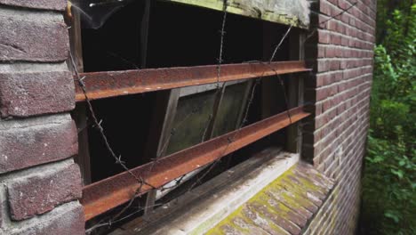 rusty window in abandoned brick building