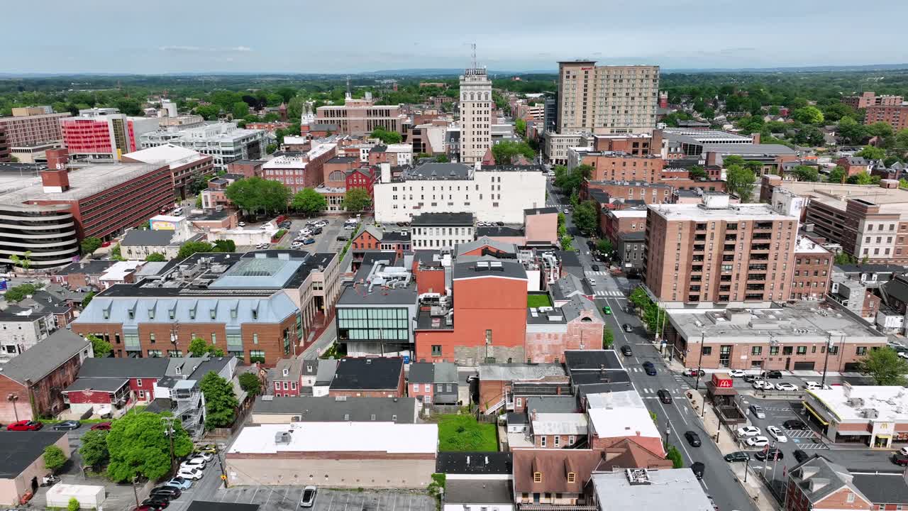 American city downtown of Lancaster in Pennsylvania At sunny spring day. Aerial lateral wide shot. High-rise office buildings and traffic on roads at daytime.