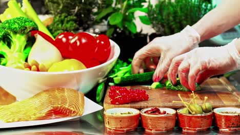 hands chopping vegetables in kitchen with fresh produce around
