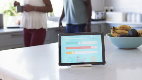 A-diverse-couple-examines-smart-home-app-energy-usage-on-a-tablet