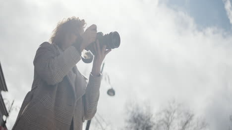 woman taking photo on city street