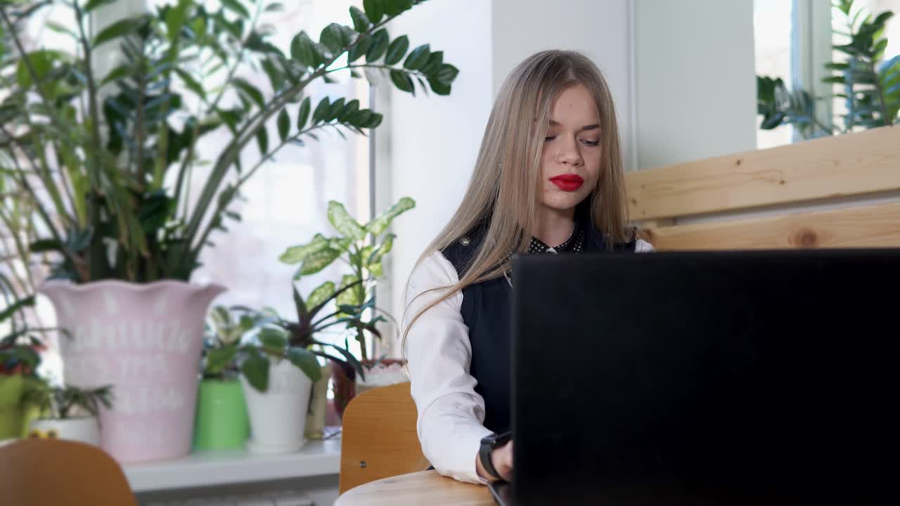 mujer trabajando en una computadora portátil en un café