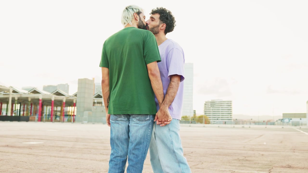 屋外で手をつないでキスしている愛情深い同性カップル。