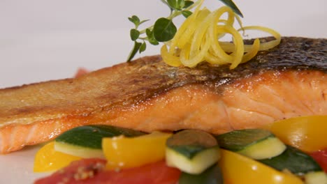 close-up of a beautifully plated salmon with crispy skin and fresh vegetables