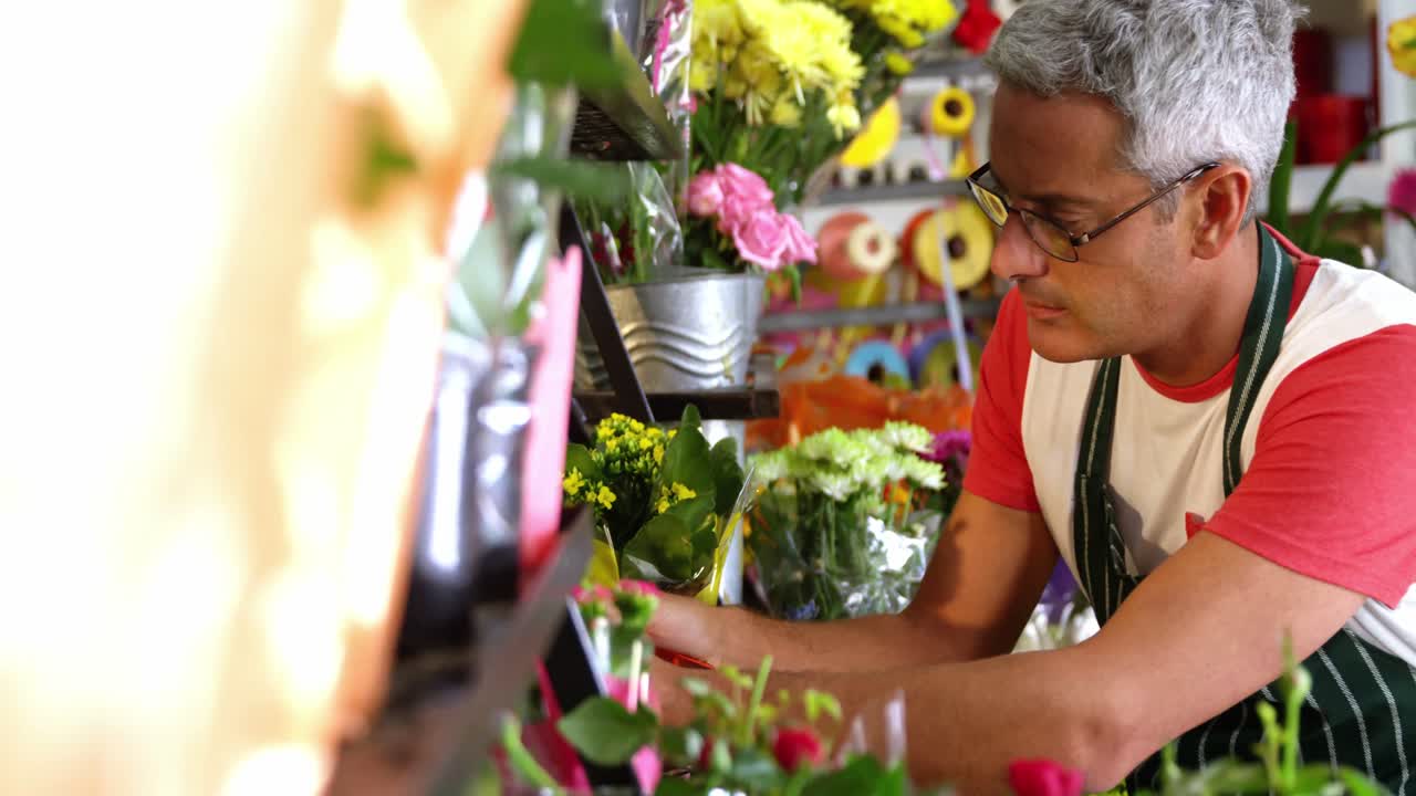 florista masculino arreglando un ramo de flores en una tienda de flores