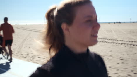 fit woman jogging slowly on the pathway of beach santa monica, on a harsh sunny day