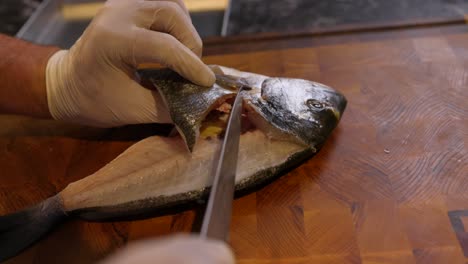 chef skilfully slicing and filleting fish on cutting board