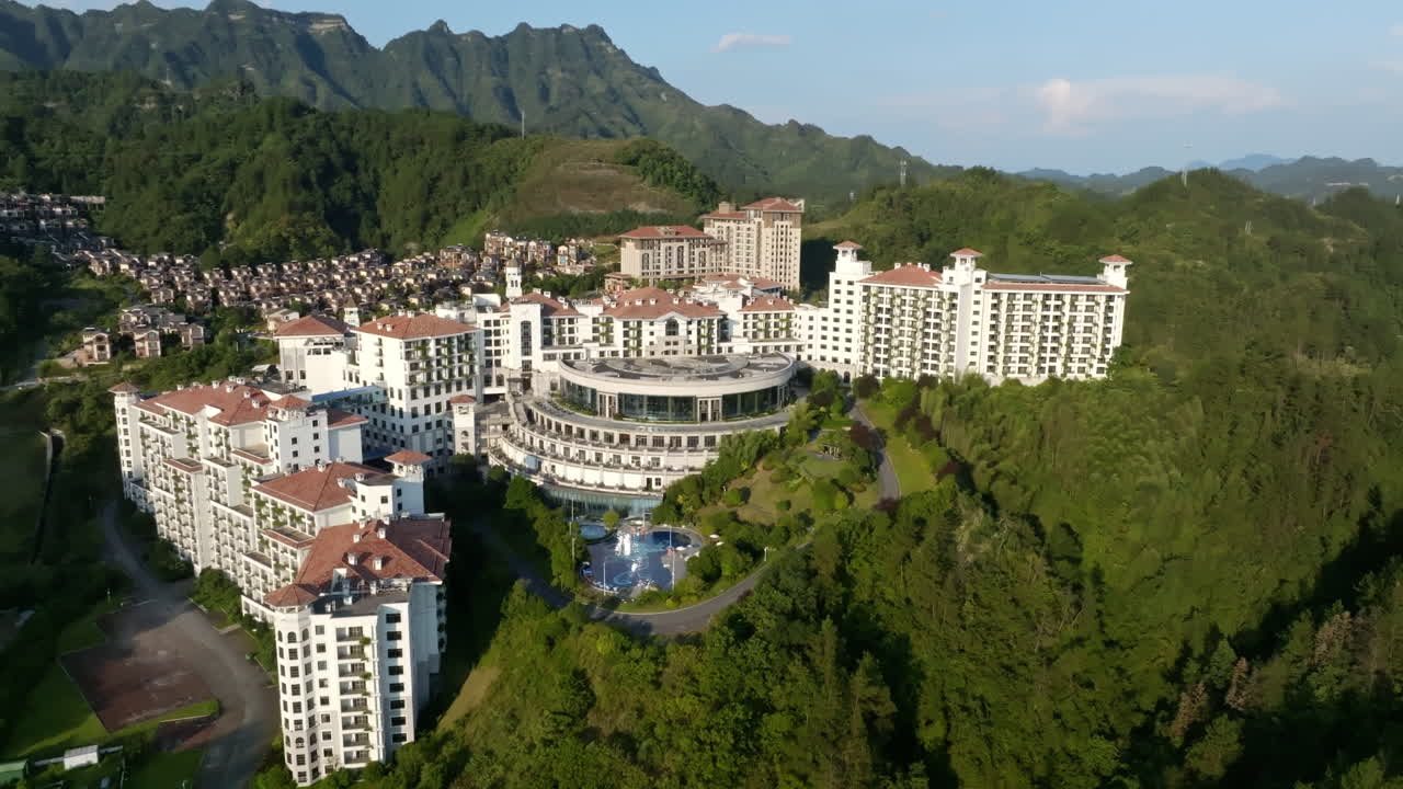 Aerial view rotating in front of a massive hotel complex, golden hour in China