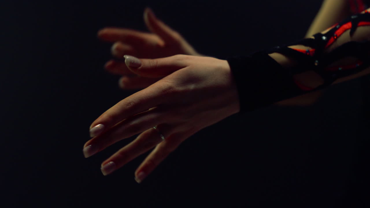 manos de mujer lanzando palos de gimnasia. gimnasta desconocida entrenando en el interior.