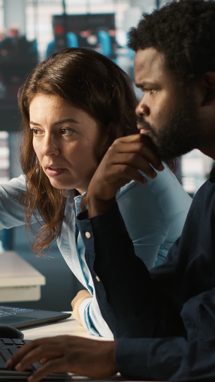 Vertical video Manager supervising work done by accountant inputting financial figures on PC