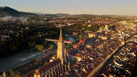 View over the oldcity of Bern Switzerland and its famous church &quot;Berner Münster&quot; while a tram passing by the bridge in behind