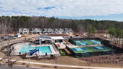 aerial panorama view of tennis courts and outdoor swimming pool in luxury estate