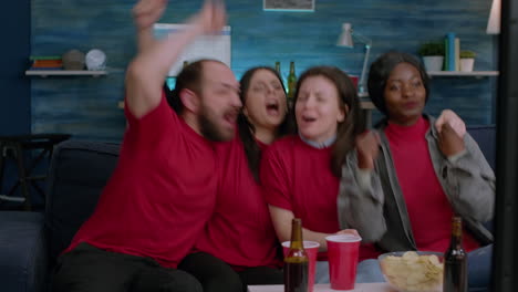 Emocionados-Amigos-De-Raza-Mixta-Viendo-Deportes-En-La-Televisión-Celebrando-Un-Gol-De-Fútbol