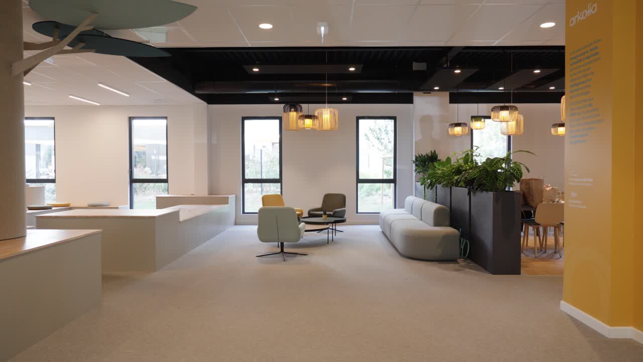 Slow revealing shot of an empty modern office with sofas and chairs