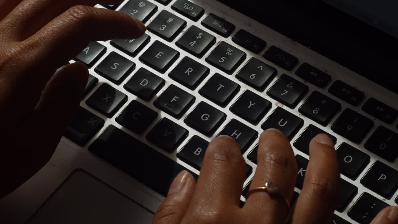 A close up shot of a woman typing on her laptop as she works from home