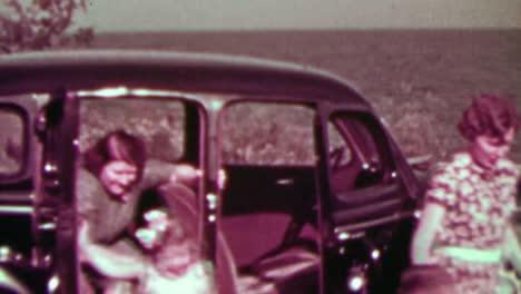 1937: family exiting rear-hinged suicide door car visiting oceanside.