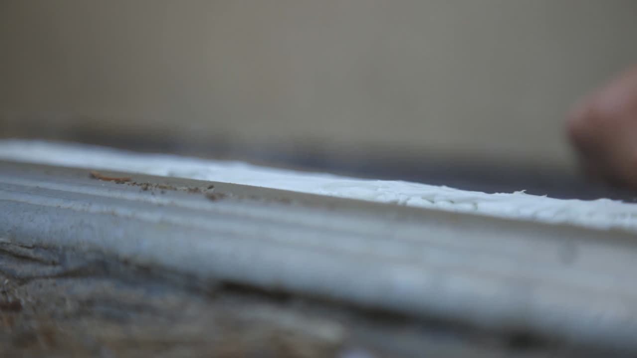 raspar el exceso de sellador de silicona sellado en la junta - primer plano