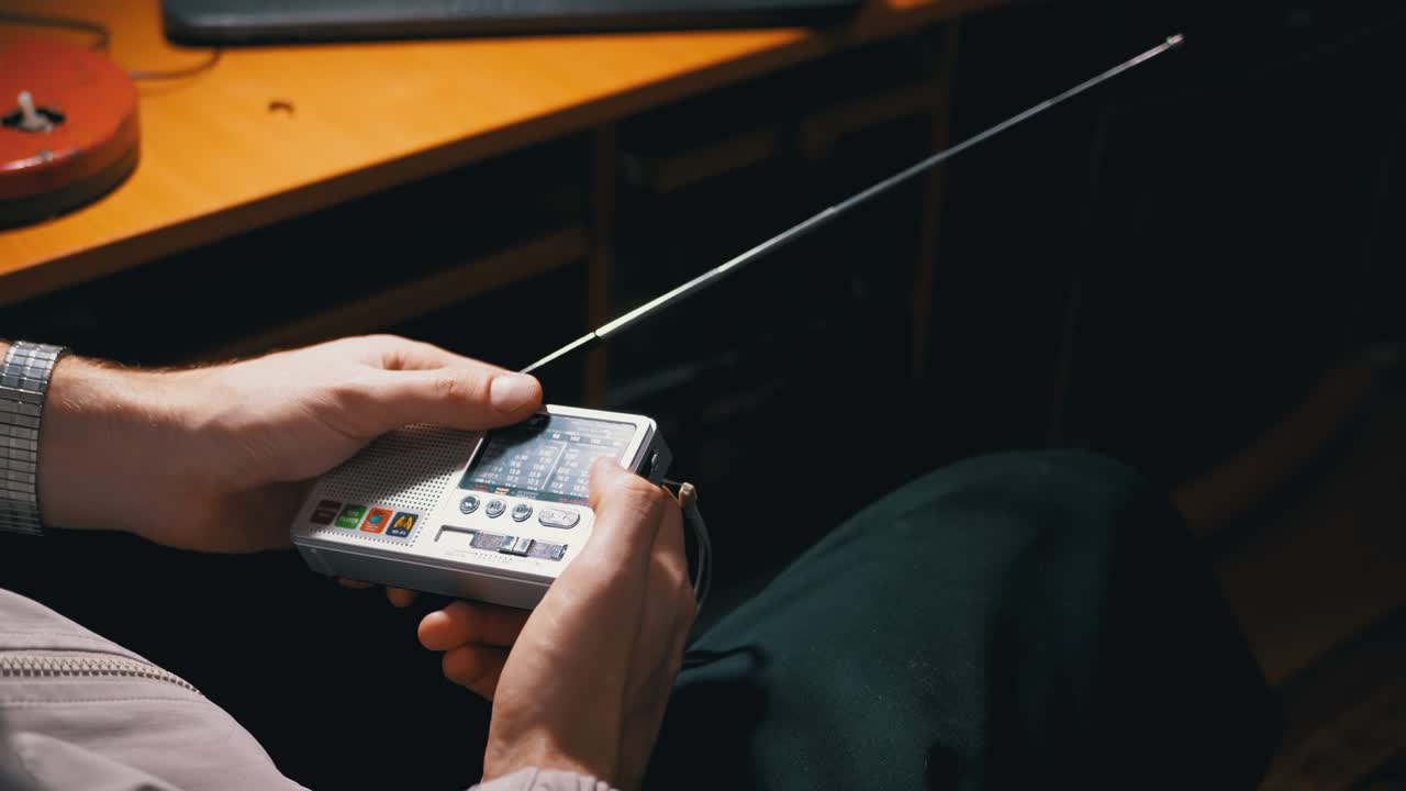 A Male Tunes a Radio Frequency on a Small Receiver with an Antenna. 4K. Close up