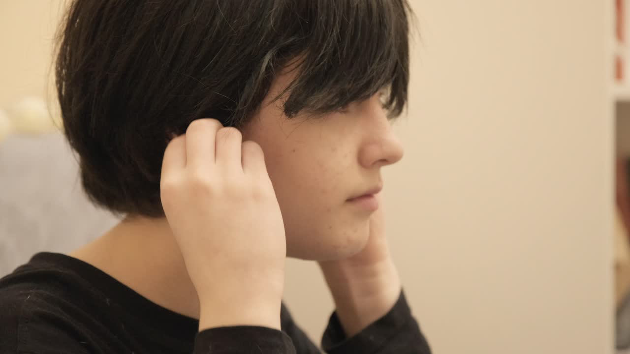 좌절 한 아이 는 밝은 노란색 귀 막기 를 착용 하고 침 ⁇  을 즐기면서 집안 의 시끄러운 혼란 에서 벗어난다