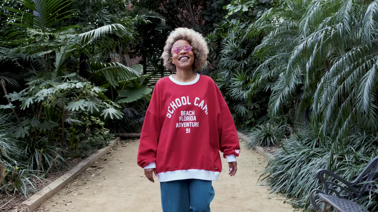 Mulher de blusa de moletom vermelha andando na trilha