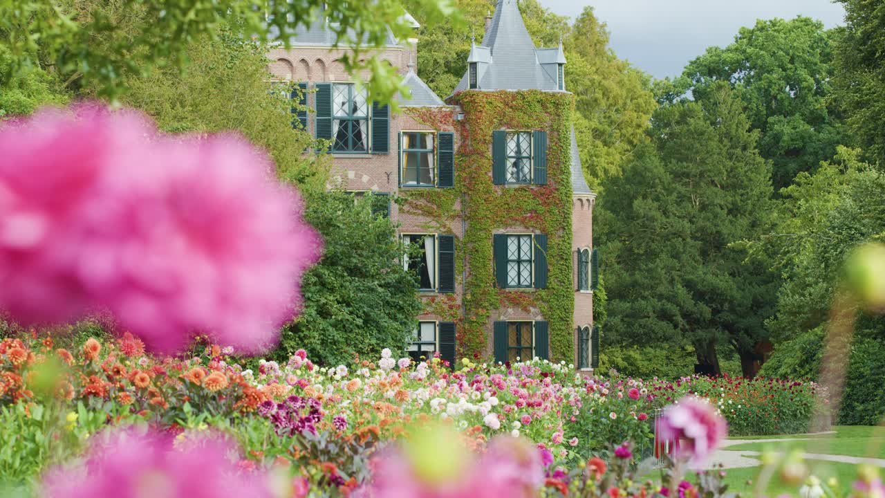 Historic castle framed by vibrant spring flowers, soft focus foreground, gentle camera movement, natural daylight