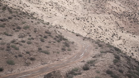 a winding dirt road through a desert landscape